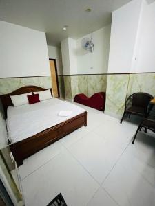 a bedroom with a bed and a chair in it at Du Thuyền 2 Hotel Hồ Chí Minh in Ho Chi Minh City +6 photos