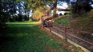 a wooden fence on a grassy hill with trees at B&B Cadrecca Tra Terra Luna e Mare in Licciana Nardi