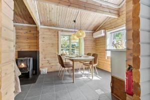 a dining room with a table and a fireplace at 84144-Ronde-Noddevej-22 in Rønde