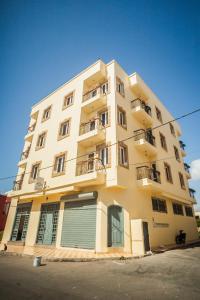 un edificio alto de color amarillo con 2 balcones en Résidence Louzani, en Essaouira