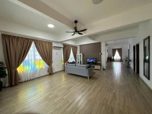 a living room with a couch and a ceiling fan at Pearl Castlestay in Tanjung Karang