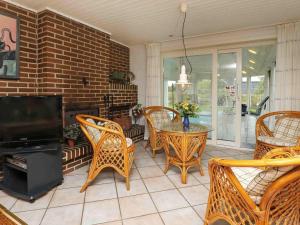 a living room with a table and chairs and a television at 6 person holiday home in Ulfborg-By Traum in Sønder Nissum