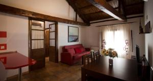 a living room with a red couch and a table at Casa Rural Casona la Beltraneja in Belmonte