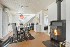a living room with a table and a fireplace at 8004-Knebel-Vestre-Strandvej-19-A in Knebel