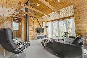 a living room with a couch and chairs and a television at 8004-Knebel-Vestre-Strandvej-19-A in Knebel