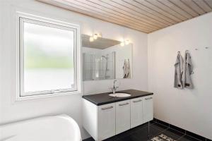 a white bathroom with a sink and a window at 8007-Knebel-Soren-Jeppesens-Vej-5 in Knebel +18 photos
