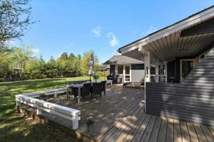 a deck with a table and chairs on a house at 8007-Knebel-Soren-Jeppesens-Vej-5 in Knebel