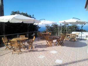 a group of tables and chairs with umbrellas at Marficas Hostel in Urzelina