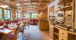 a kitchen with wooden cabinets and tables and chairs at Garni Ortles in Selva di Val Gardena