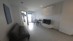 a living room with a couch and a table at Tranquil Tide 1 BR T1-605 in Ban Klang