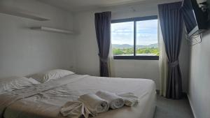 a bedroom with a bed with towels on it at Tranquil Tide 1 BR T1-605 in Ban Klang
