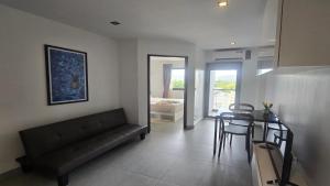 a living room with a black couch and a table at Tranquil Tide 1 BR T1-605 in Ban Klang