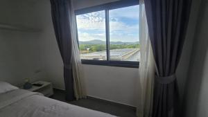 a bedroom with a window with a view of an airport at Tranquil Tide 1 BR T1-605 in Ban Klang