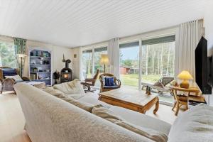 un salon avec un canapé et une table dans l'établissement 84176-Ebeltoft-Birkevej-10, à Ebeltoft