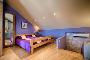 een slaapkamer met paarse muren en een bed en een spiegel bij Apartments Villa Anka in Komiža