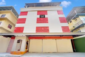 a building with a red and white facade at Super Hotel O Broadway Ernakulam in Cochin