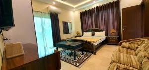 a bedroom with a bed and a couch in a room at Hotel Luxe Heights Lahore in Lahore