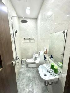 a white bathroom with a toilet and a sink at La La Sky Homestay Phu Quoc in Phu Quoc