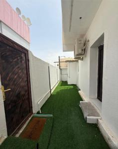 an empty corridor of a building with green grass at New Manaser apartment in Al Ain