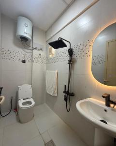 a bathroom with a sink and a toilet and a mirror at New Manaser apartment in Al Ain