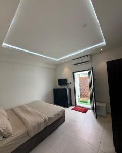 a white bedroom with a bed and a window at New Manaser apartment in Al Ain