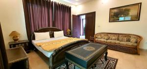 a bedroom with a bed and a couch in it at Hotel Luxe Heights Lahore in Lahore +3 photos