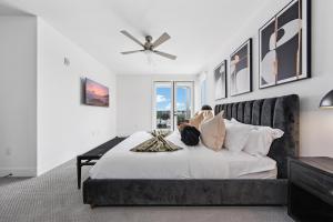 a woman sitting on a bed looking out the window at Sea Breeze Escape 3BR Coastal Gem with 2 Balconies in Los Angeles
