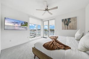 a white bedroom with a bed and a large window at Sea Breeze Escape 3BR Coastal Gem with 2 Balconies in Los Angeles