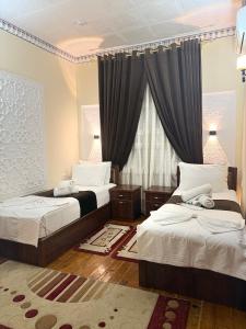 Un dormitorio con dos camas y una ventana. en Zaringiz INN Boutique, en Bukhara