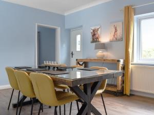 a dining room with a table and yellow chairs at Lanes Farm in Eakring