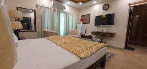 a bedroom with a large bed and a television at Hotel Luxe Heights Lahore in Lahore