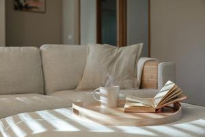 a tray with a coffee cup and a book on a couch at The Willows Coastal Retreat in Old Ocean Grove in Ocean Grove