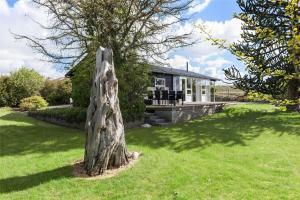 a tree stump in the grass in front of a house at 8442-Ronde-Lindeparken-56 in Rønde