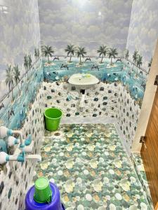 a bathroom with a pool and palm trees at Deeksha homestay in Hampi