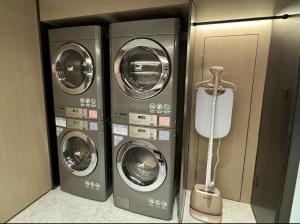 two washers and a dryer in a room at Hanting Hotel Beijing Wukesong Yongding Road in Beijing