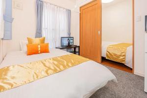 una camera da letto con un grande letto con un cuscino arancione di Akihabara Skytree Premium Apartment 102 a Tokyo