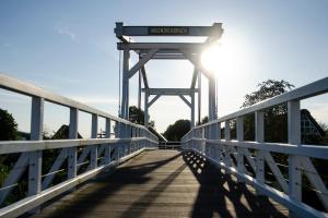 un pont sur une rivière où le soleil brille dans l'établissement Kirschpfad zur Lühe, à Grünendeich