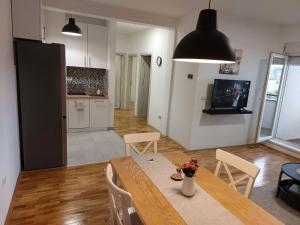 a kitchen and dining room with a table and chairs at Apartman 028 in Smederevska Palanka