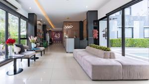 a living room with a couch and a table at Gate43 Airport Hotel in Lat Krabang