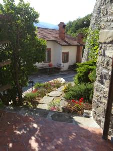 a house with a garden with flowers in front of it at Casa Vacanze Nonna Nella in Villafranca in Lunigiana