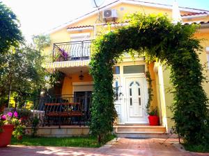 uma casa amarela com um arco em frente em Sonja Vacation House em Porec