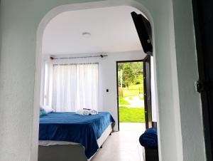 a bedroom with a bed with a blue comforter and a window at Habitación 201 boutique in Paipa