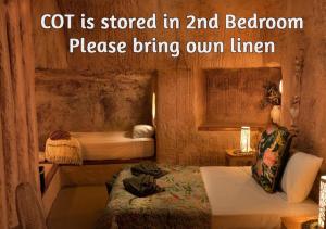 a small room with two beds in a room at Ali's Underground Home in Coober Pedy