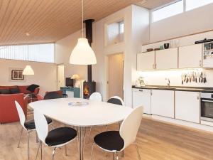 a dining room and kitchen with a white table and chairs at Scenic Golf Retreat-By Traum in Bogense