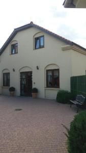 a white house with a brick driveway in front of it at Zajazd Pod Dyliżansem in Kościelec