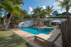 a swimming pool with a bench next to a house at Confraria Colonial Hotel Boutique in Mairinque