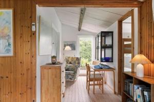 a living room with a table and a chair in a room at 1585-Vejby-Plovmandsvang-27 in Vejby
