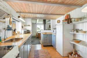 cocina con electrodomésticos blancos y techo de madera en 314-Harboore-Flyvholmvej-21, en Harboør 21 fotos más