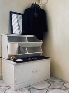 a dresser with a mirror and a shirt hanging on a wall at Casa De Hombre in Santo Tomas +8 photos