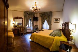 a bedroom with a large bed and a large window at Hotel Palazzo Alexander in Lucca